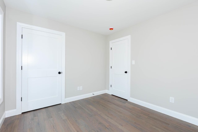 unfurnished bedroom with wood finished floors and baseboards