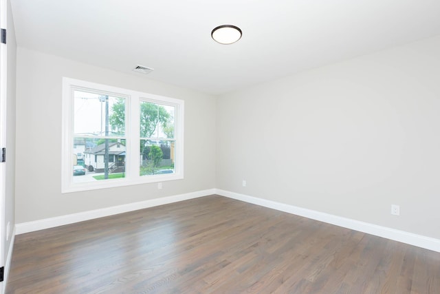 spare room featuring dark wood finished floors and baseboards