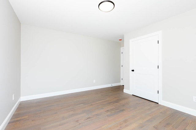 empty room featuring wood finished floors and baseboards