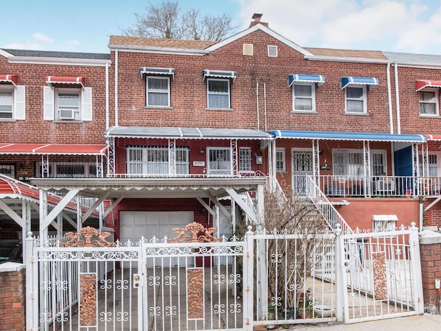 3317 Gunther Ave, Bronx, NY 10469 - townhome / multi-family property with a garage, brick siding, a fenced front yard, and a gate