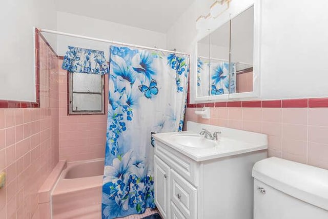 3317 Gunther Ave, Bronx, NY 10469 - bathroom with a wainscoted wall, toilet, vanity, tile walls, and shower / bath combo with shower curtain