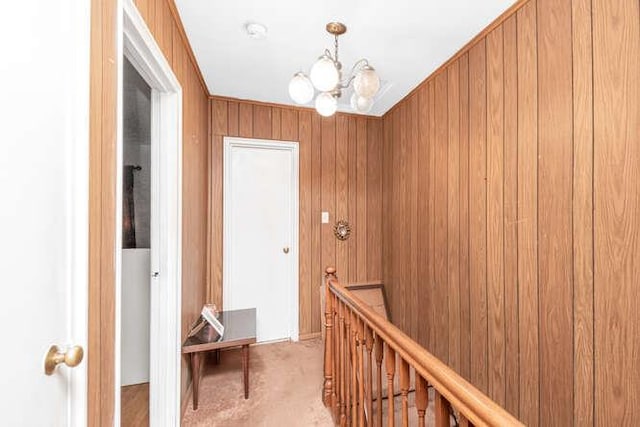 3317 Gunther Ave, Bronx, NY 10469 - hall featuring light colored carpet, wood walls, a notable chandelier, and an upstairs landing