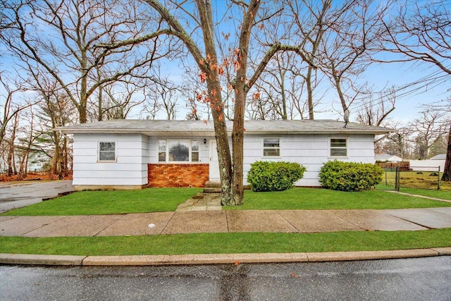 view of front of home with a front yard and fence