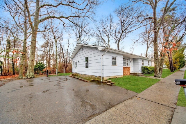 view of home's exterior featuring a lawn and driveway