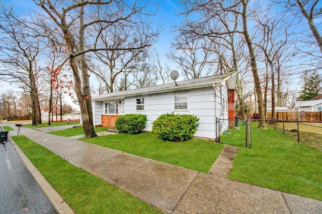view of front of house featuring fence and a front lawn