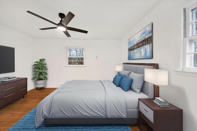 bedroom featuring baseboards, wood finished floors, and ceiling fan