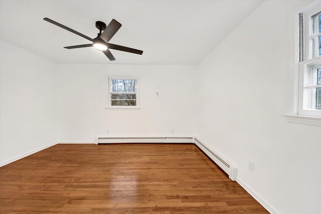 spare room featuring a wealth of natural light, wood finished floors, a ceiling fan, and a baseboard radiator