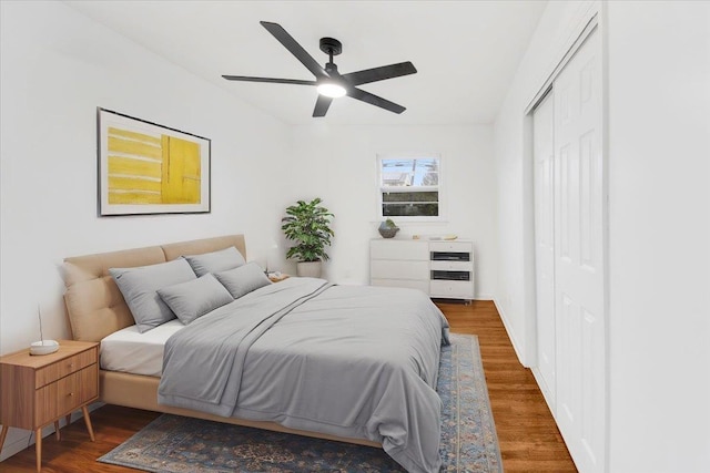bedroom with a closet, wood finished floors, and a ceiling fan