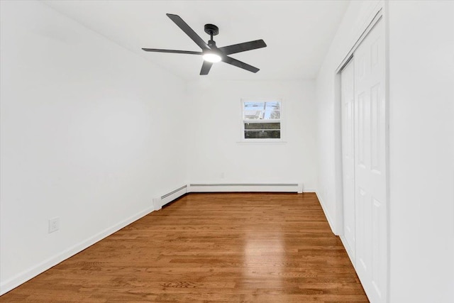 unfurnished bedroom with baseboards, a closet, wood finished floors, and a ceiling fan