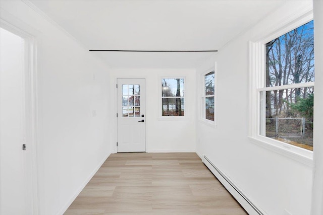 entryway with a baseboard radiator, baseboards, and light wood finished floors