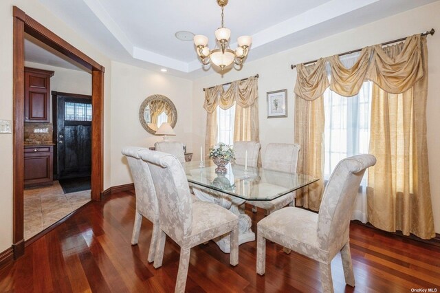 37-12 222nd St, Bayside, NY 11361 - dining space featuring a tray ceiling, baseboards, a chandelier, and wood finished floors