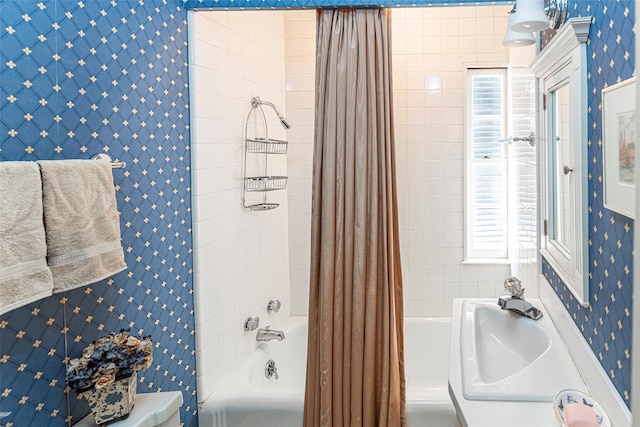 bathroom with shower / bath combo and wallpapered walls