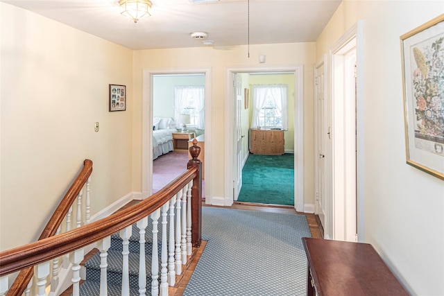 hall with baseboards and an upstairs landing