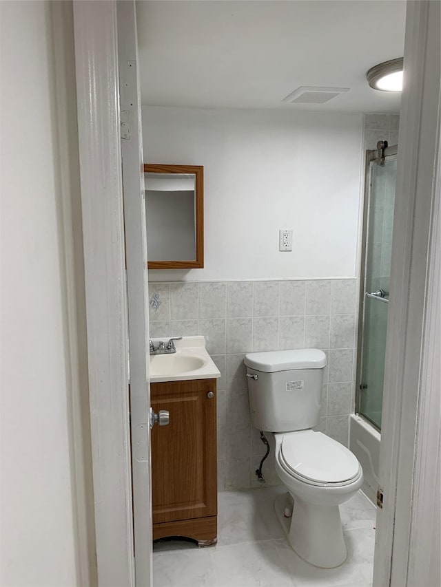 2263 Ryer Ave, Bronx, NY 10457 - full bathroom featuring shower / bath combination with glass door, toilet, vanity, visible vents, and tile walls