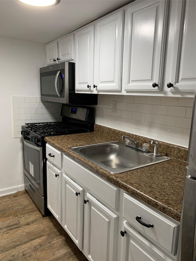 2263 Ryer Ave, Bronx, NY 10457 - kitchen featuring white cabinetry, stainless steel appliances, dark wood finished floors, a sink, and dark countertops
