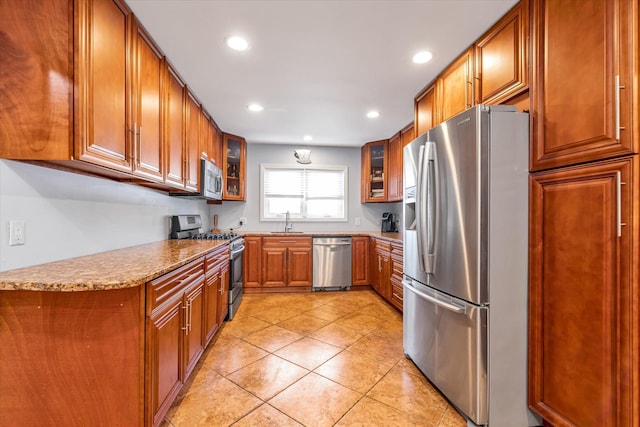 580 Foxhurst Rd, Baldwin, NY 11510 - kitchen featuring stainless steel appliances, brown cabinetry, recessed lighting, a sink, and glass insert cabinets
