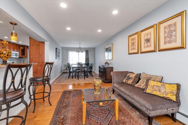 580 Foxhurst Rd, Baldwin, NY 11510 - living room featuring recessed lighting, light wood-style floors, a chandelier, a baseboard radiator, and baseboards
