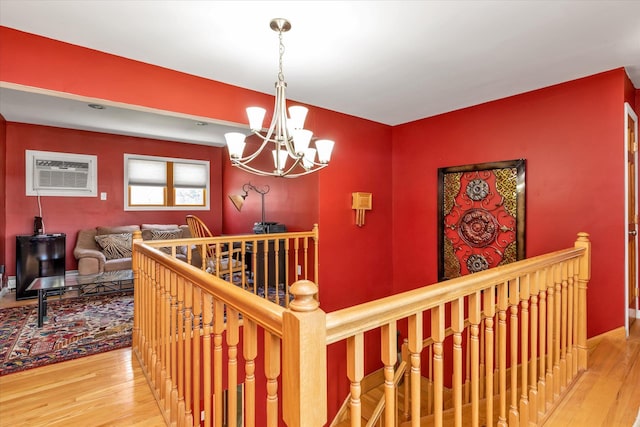 580 Foxhurst Rd, Baldwin, NY 11510 - hallway with an upstairs landing, a chandelier, a wall mounted air conditioner, and wood finished floors