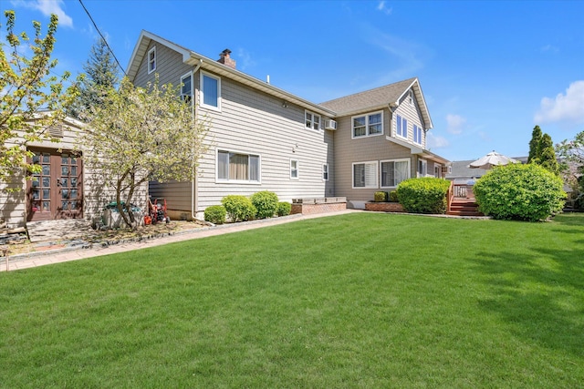 580 Foxhurst Rd, Baldwin, NY 11510 - back of property with a chimney, a lawn, and a wooden deck