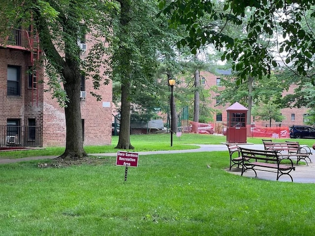 view of property's community featuring a yard and fence