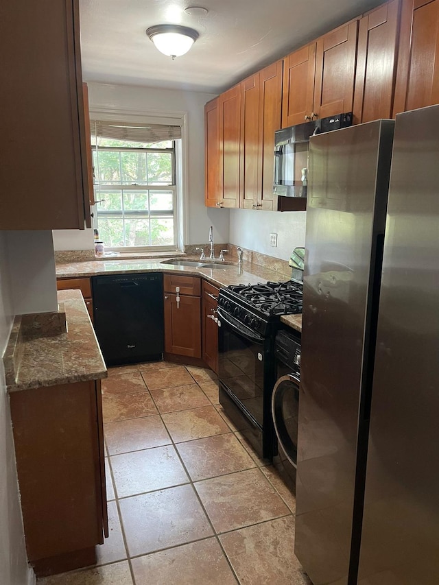 78-05 Park Dr E Unit 4B, Kew Garden Hills, NY 11367 - kitchen with black appliances, washer / clothes dryer, stone countertops, light tile patterned flooring, and brown cabinets