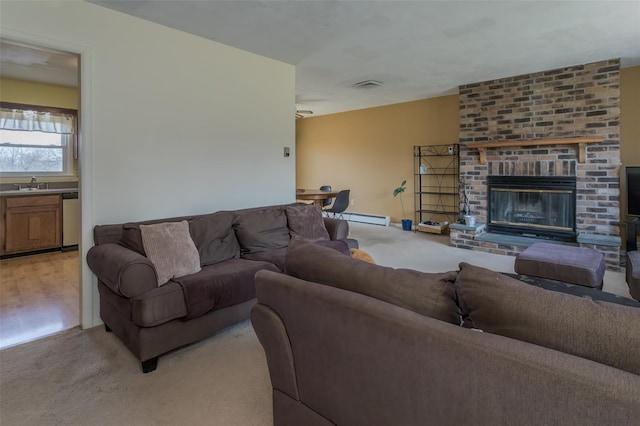 living room featuring a baseboard radiator, visible vents, and a brick fireplace