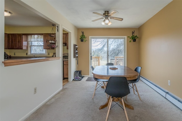 dining room with ceiling fan, baseboards, light colored carpet, and baseboard heating