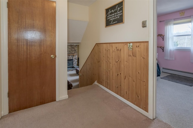 hallway featuring a baseboard heating unit and carpet