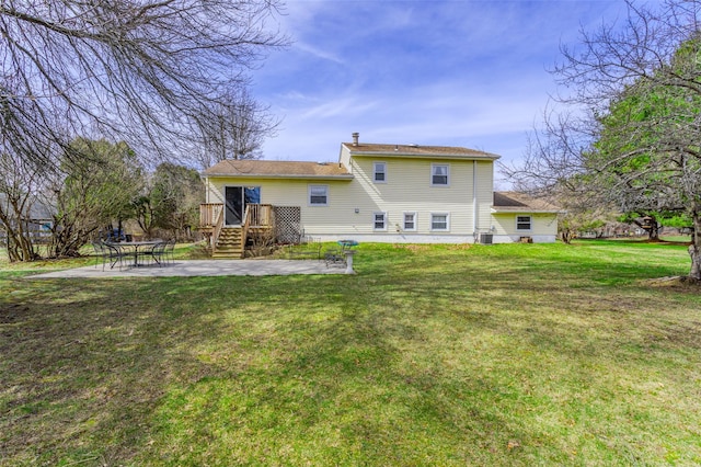 back of house with a wooden deck, a patio area, and a yard