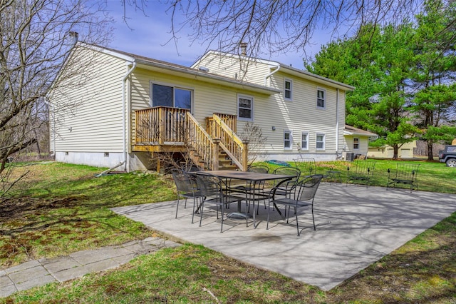 back of house featuring a lawn, outdoor dining area, a patio, and crawl space