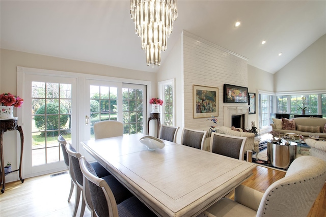 65 Elm Dr, East Hills, NY 11576 - dining area with high vaulted ceiling, light wood-type flooring, recessed lighting, a chandelier, and a fireplace