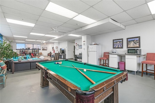 playroom with a ceiling fan, a paneled ceiling, finished concrete floors, and billiards