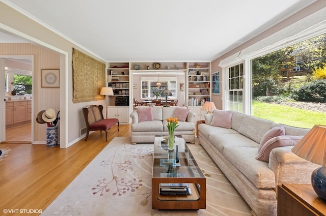 living room with wood finished floors, baseboards, and built in shelves