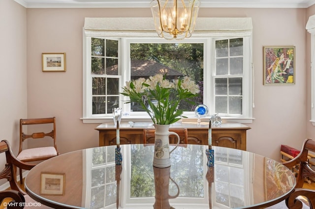dining area featuring crown molding and an inviting chandelier