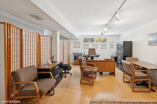 office area with track lighting, visible vents, and light wood finished floors