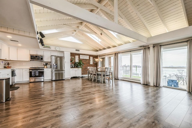 200 Block Ln, Island Park, NY 11558 - kitchen with appliances with stainless steel finishes, white cabinetry, dark wood-type flooring, light countertops, and high vaulted ceiling