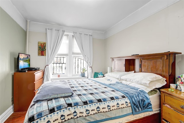 bedroom featuring baseboards and wood finished floors