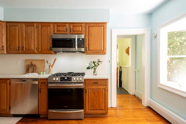 27 Powder Mill Rd, Newburgh, NY 12550 - kitchen featuring appliances with stainless steel finishes, light countertops, light wood-type flooring, and brown cabinets