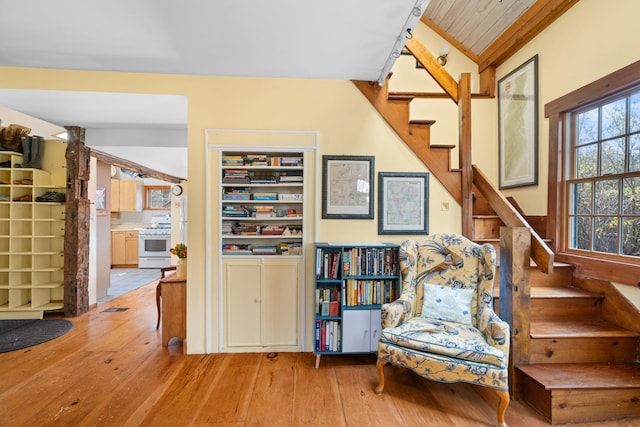living area featuring lofted ceiling, stairs, and hardwood / wood-style floors