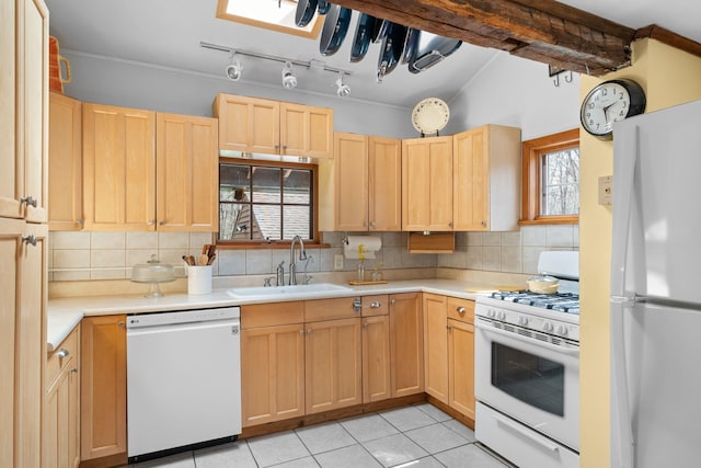 kitchen with light brown cabinets, a sink, white appliances, light countertops, and backsplash