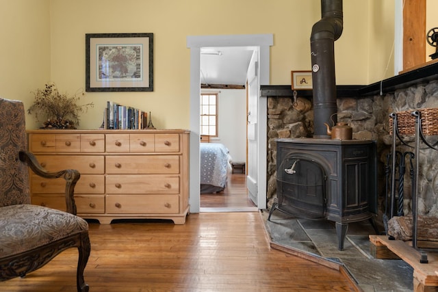 sitting room featuring hardwood / wood-style flooring and a wood stove