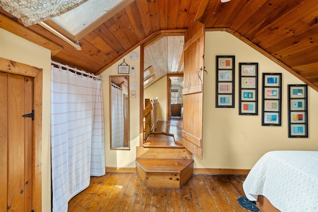 bedroom with wood ceiling, wood-type flooring, vaulted ceiling, and baseboards