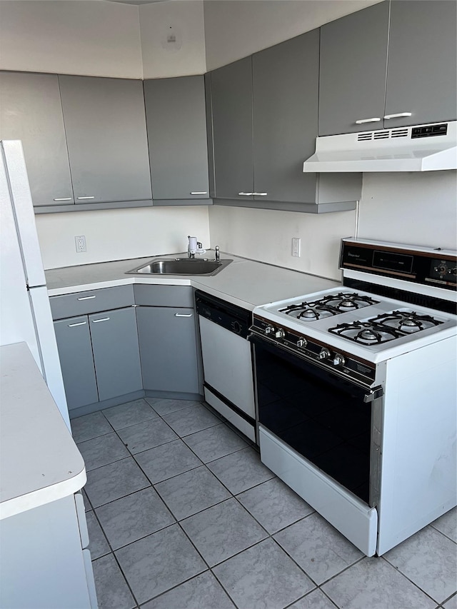 kitchen with gray cabinetry, under cabinet range hood, white appliances, and a sink