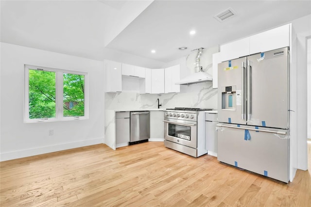 76-17 162nd St, Fresh Meadows, NY 11366 - kitchen featuring visible vents, modern cabinets, wall chimney exhaust hood, white cabinets, and appliances with stainless steel finishes