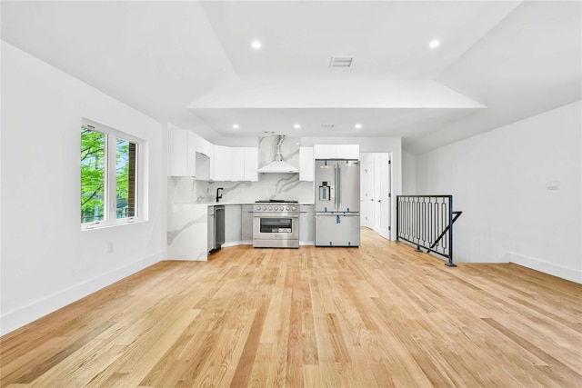 76-17 162nd St, Fresh Meadows, NY 11366 - interior space with wall chimney range hood, visible vents, appliances with stainless steel finishes, light countertops, and white cabinetry