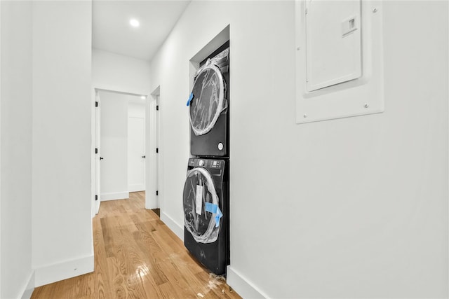 76-17 162nd St, Fresh Meadows, NY 11366 - laundry room with laundry area, stacked washing maching and dryer, baseboards, light wood-type flooring, and electric panel