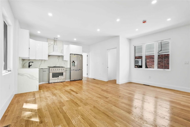76-17 162nd St, Fresh Meadows, NY 11366 - kitchen with appliances with stainless steel finishes, light countertops, wall chimney exhaust hood, white cabinetry, and recessed lighting