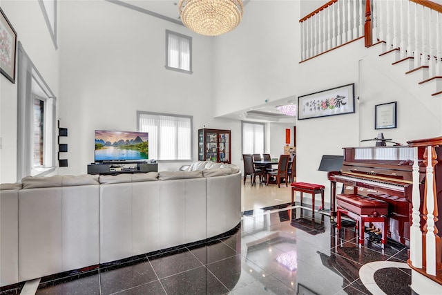 living room featuring a high ceiling, an inviting chandelier, and granite finish floor
