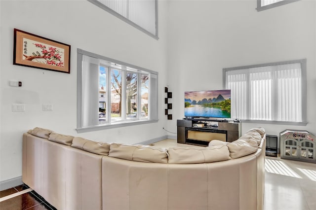 living room with a high ceiling and baseboards