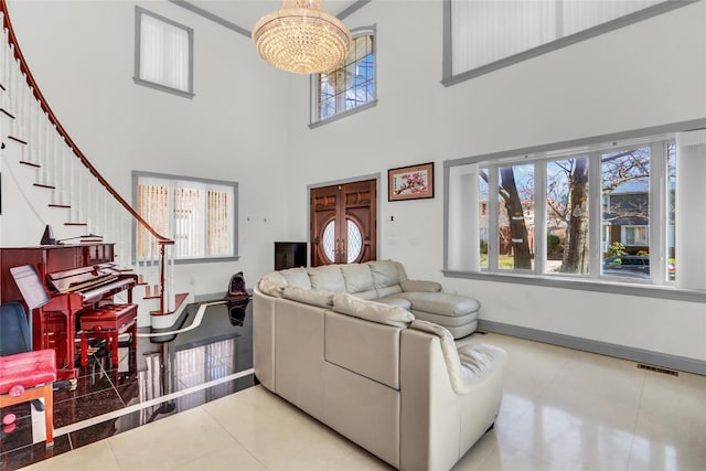 tiled living room with a healthy amount of sunlight, a notable chandelier, stairway, and visible vents